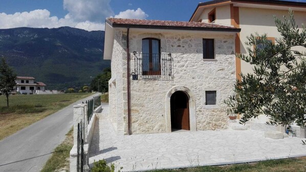 A stone building with a balcony, a wooden door, and a small window. - Small Alvitano shelter (Alvito, Frosinone)