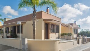 A two-story residential building with a beige facade, a central entrance, and a small balcony. - Newly built villa: Car garage, 3 bedrooms, 6p let, large kitchen, gardens (Tuglie)