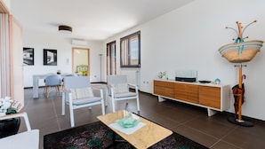 A modern living room with a sofa, chairs, a coffee table, a TV, and a decorative basket on a stand. - Newly built villa: Car garage, 3 bedrooms, 6p let, large kitchen, gardens (Tuglie)