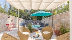 An outdoor patio with wicker furniture, a pool, and a stone wall. - Salento Rosa dei Venti - Scirocco (Surbo)