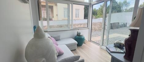 Une pièce avec un canapé, un grand vase et une table avec une lampe.