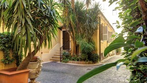 A cobblestone street with a building featuring a staircase and a door. - Rome Boutique Apartments with terrace, whirlpool in room, central.   (6900335)