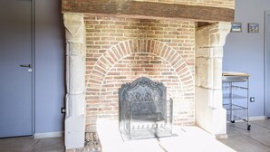 A brick fireplace with a decorative screen, a metal cart, and a door. - 3 bedroom awesome home in Hattenville (Hattenville)