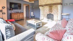 A living room with a fireplace, a television, and a sofa. - 3 bedroom awesome home in Hattenville (Hattenville)