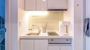 A modern kitchen with white cabinetry, a stainless steel sink, a coffee machine, and a dishwasher. - The Phase Boutique Hotel (Seoul)