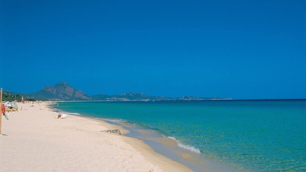 A beach with clear turquoise water, a sandy shore, and a mountain in the background. - Lovely home in Costa Rei -CA- (Costa Rei -CA-)