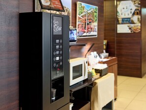 A self-service coffee machine with a digital display and various beverage options.