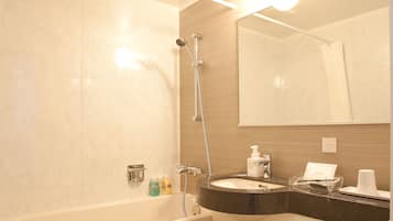 A modern bathroom with a bathtub, a sink, a toilet, and a mirror.