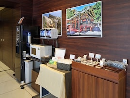 Una habitación de hotel con minibar, microondas, refrigerador y estación de café.