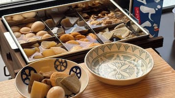 A tray of assorted food items and two bowls on a wooden table.