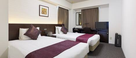 A hotel room with two beds, a desk, a television, and a mirror.