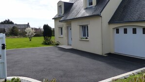 Ein zweistöckiges Haus mit Garage, Auffahrt und gepflegtem Rasen.