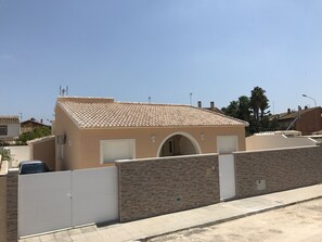 Ein eingeschossiges Gebäude mit einem Ziegeldach, einem verschlossenen Eingang und einer kleinen angebauten Garage.
