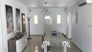 A dining area with a patterned tablecloth, a chandelier, and wall-mounted artwork. - Luxury Villa south facing-Beach 500m-Private heated pool-English TV-WiFi-BBQ (SANTIAGO DE LA RIBERA)