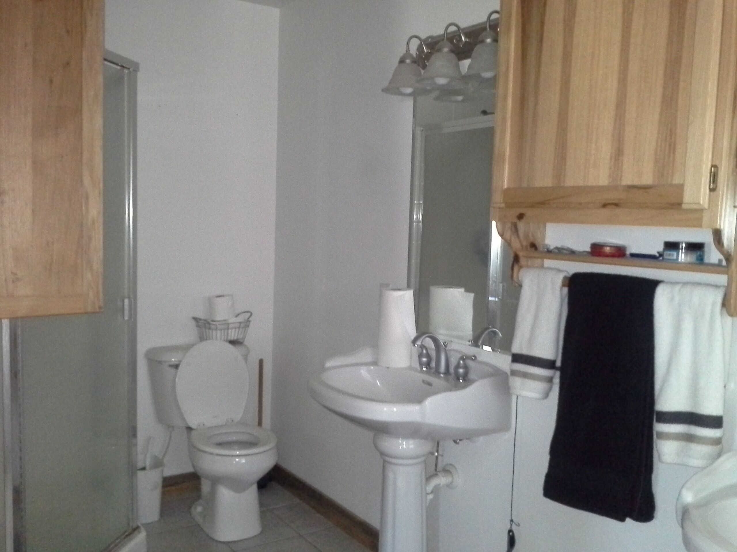 Un baño con inodoro, lavabo y espejo.