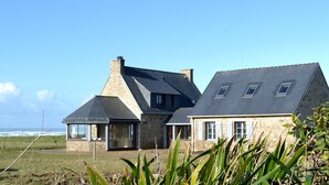 Una casa de piedra con un gran ventanal y un invernadero.