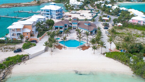 Un resort con una grande piscina, diversi edifici e una spiaggia.