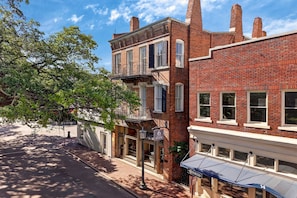 Un bâtiment en briques de deux étages, doté d’un balcon, d’une enseigne indiquant qu’il s’agit d’un bâtiment public et d’un auvent.