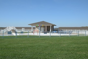 Enjoy outdoor activities in a well-maintained park setting with a covered pavilion and grassy field.