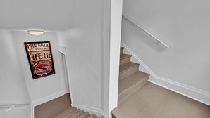 Eine Treppe mit Handlauf und einem Poster an der Wand.