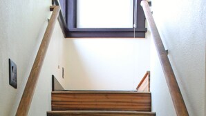 Eine Holztreppe mit Handlauf und einem Fenster am oberen Ende.