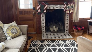 Un salón acogedor con chimenea, alfombra estampada y calcetines festivos.
