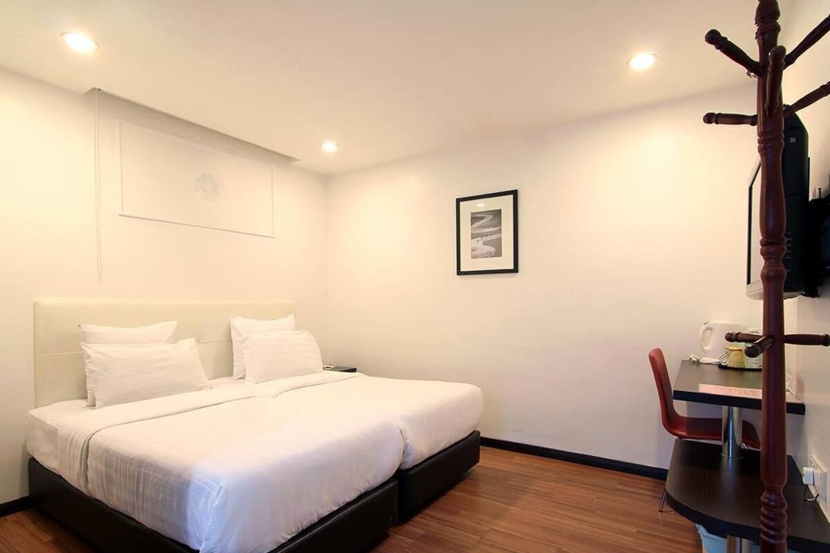 A bedroom with a bed, a desk, and a chair.