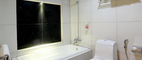A modern bathroom with a bathtub, toilet, and a glass-enclosed shower.