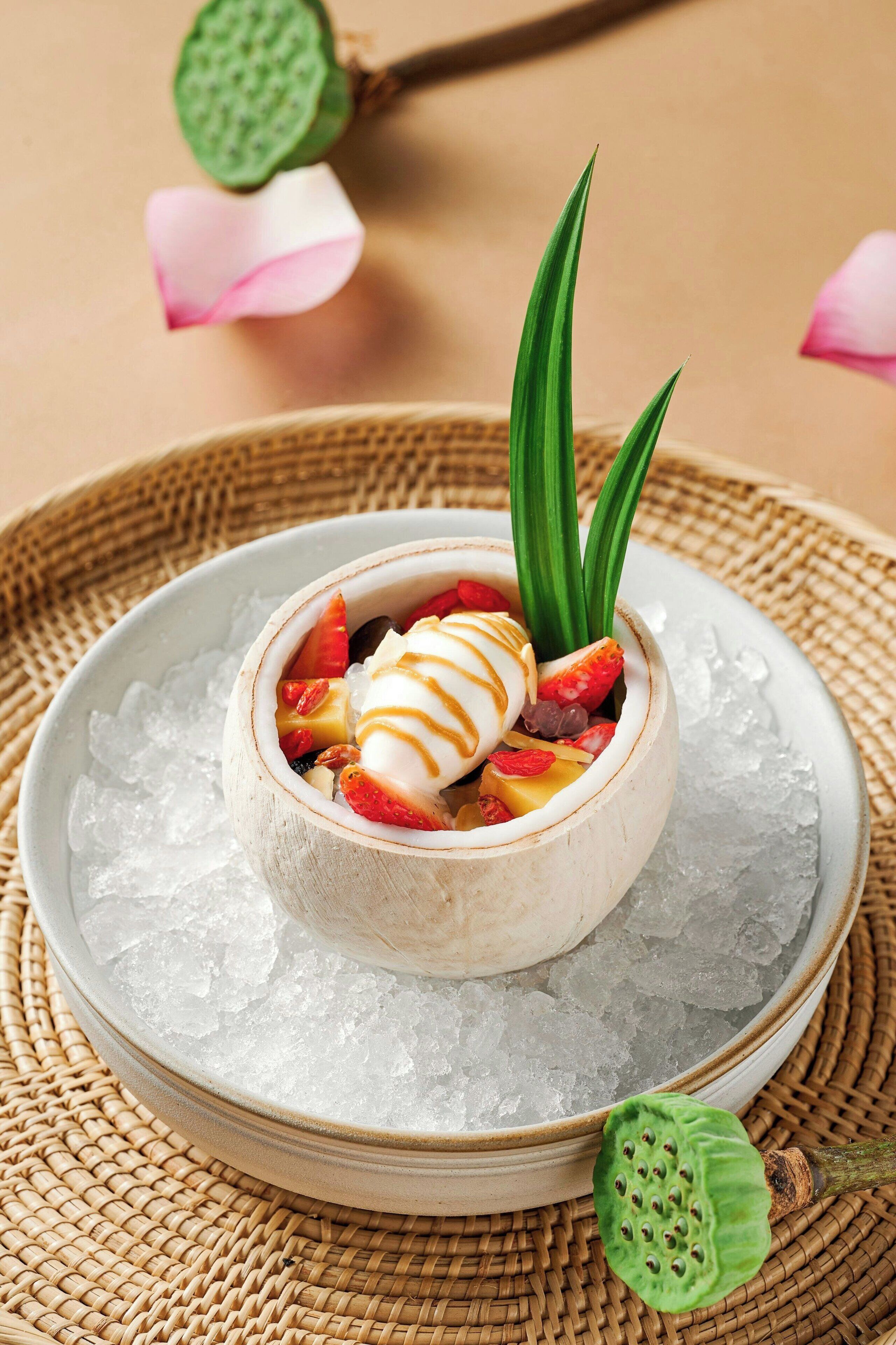 Un postre en un bol sobre hielo, con una cuchara, rodeado por un tapete tejido.