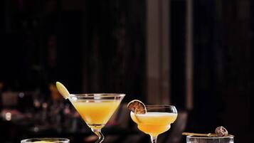Three cocktails on a bar counter with a festive background.