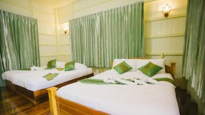 Two wooden beds with white linens and green pillows, in a room with green curtains and wall sconces. - Suan Tung Coffee (Chiang Rai)