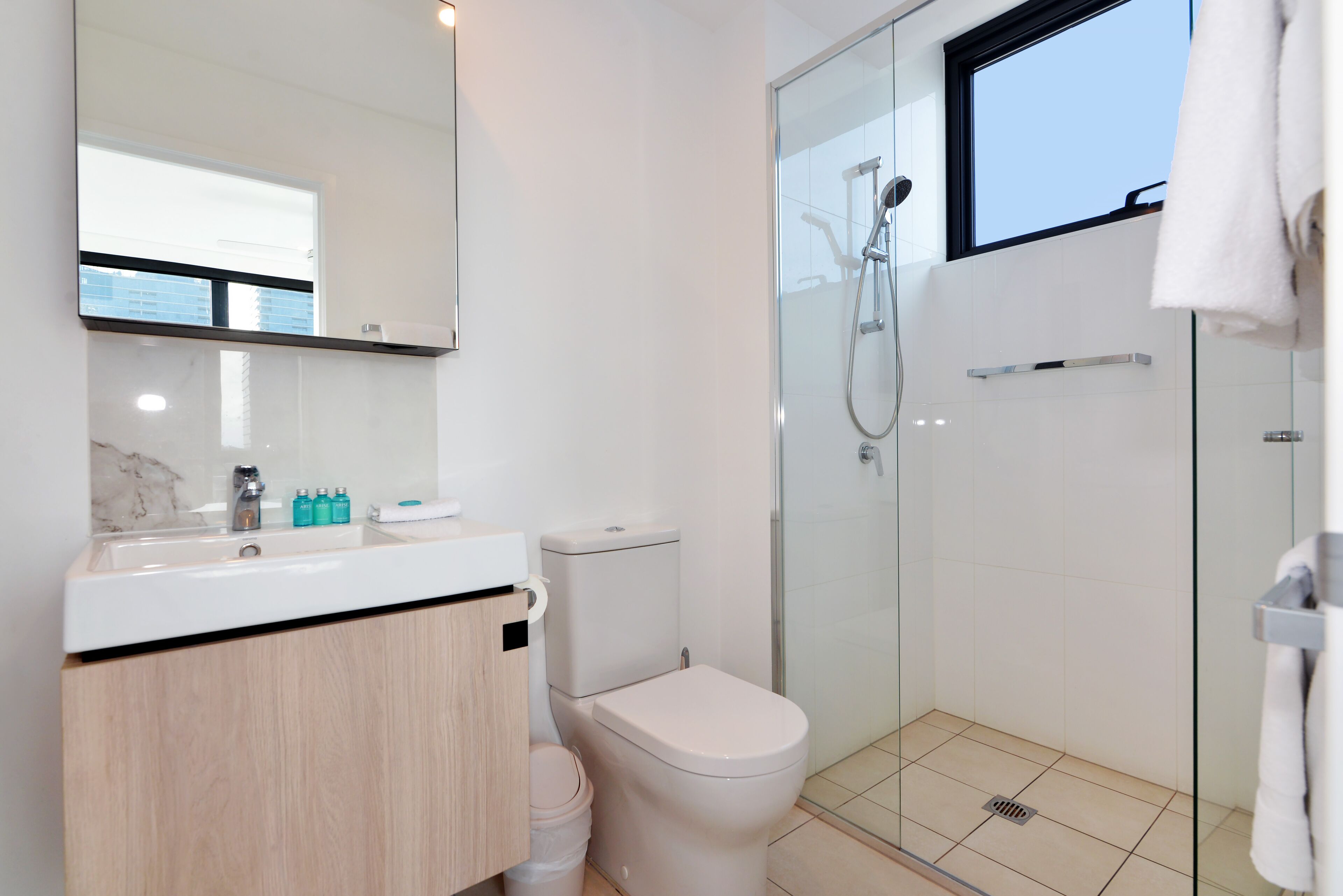 Ein modernes Badezimmer mit Toilette, Waschbecken und einer Duschkabine.