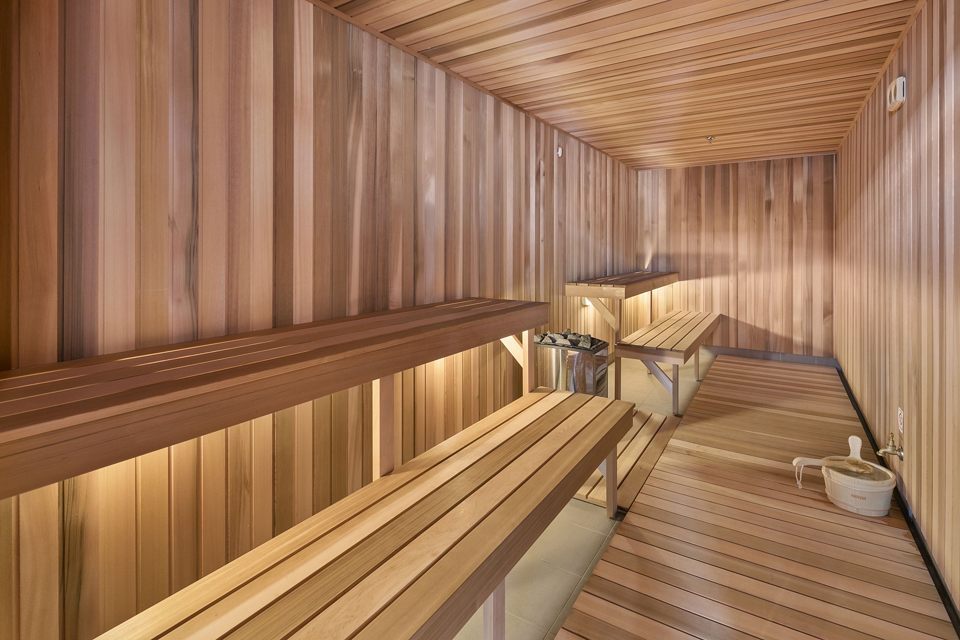 A sauna with wooden benches and a bench with a towel hanging on it.