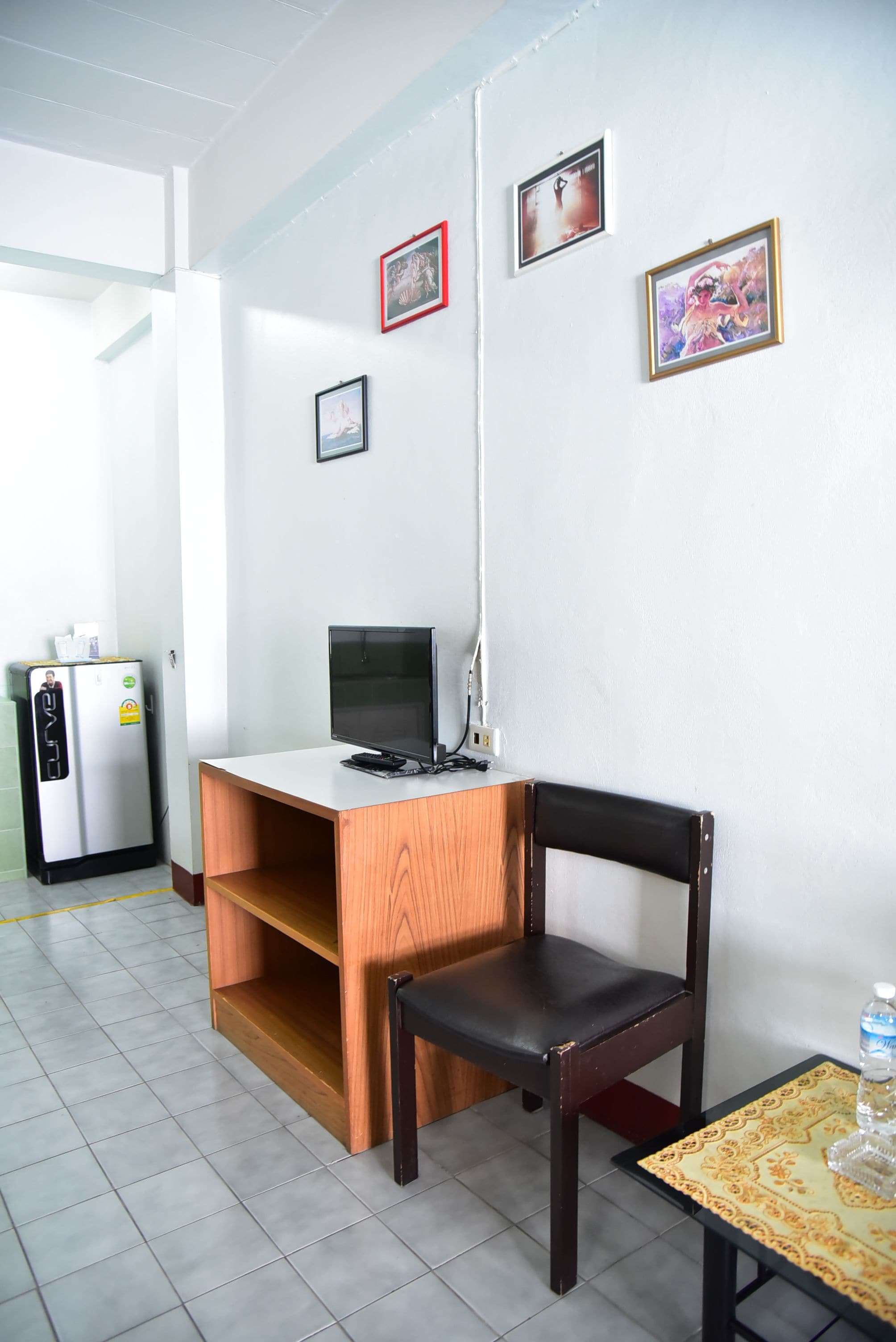 A small office space with a desk, chair, and a refrigerator.