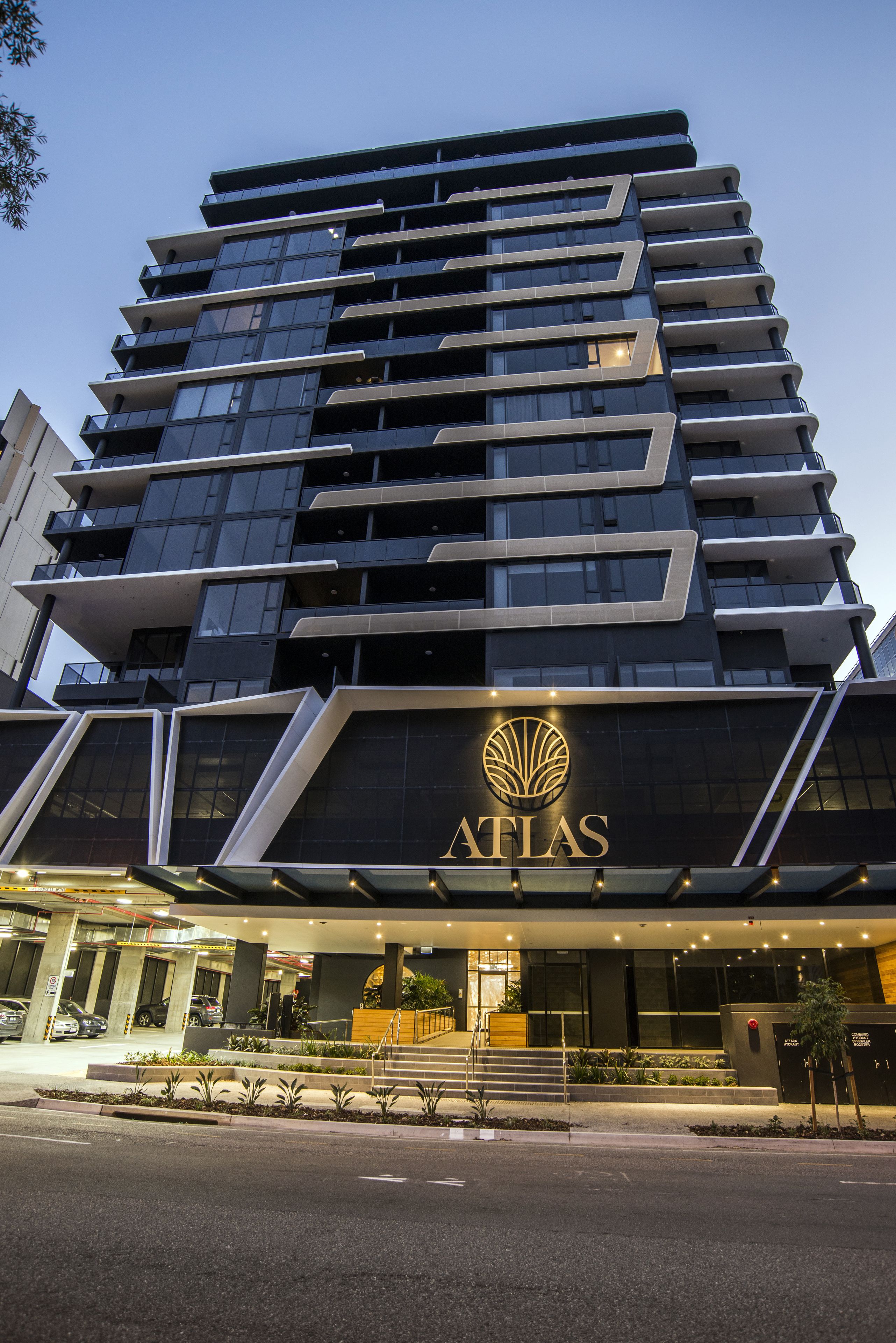A multi-story hotel with a prominent "AFLAS" sign, featuring a modern architectural design with balconies and large windows.