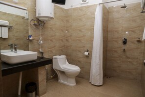 A modern bathroom with a sink, toilet, and shower. - Hotel Phuentsholing (Phuntsholing)