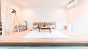 A modern living room with a sofa, a coffee table, and a hanging light fixture. - Yaoya Kyoto Kyomizu Gojo (Kyoto)