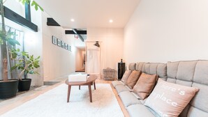 A modern living room with a grey sofa, a coffee table, and potted plants. - Yaoya Kyoto Kyomizu Gojo (Kyoto)