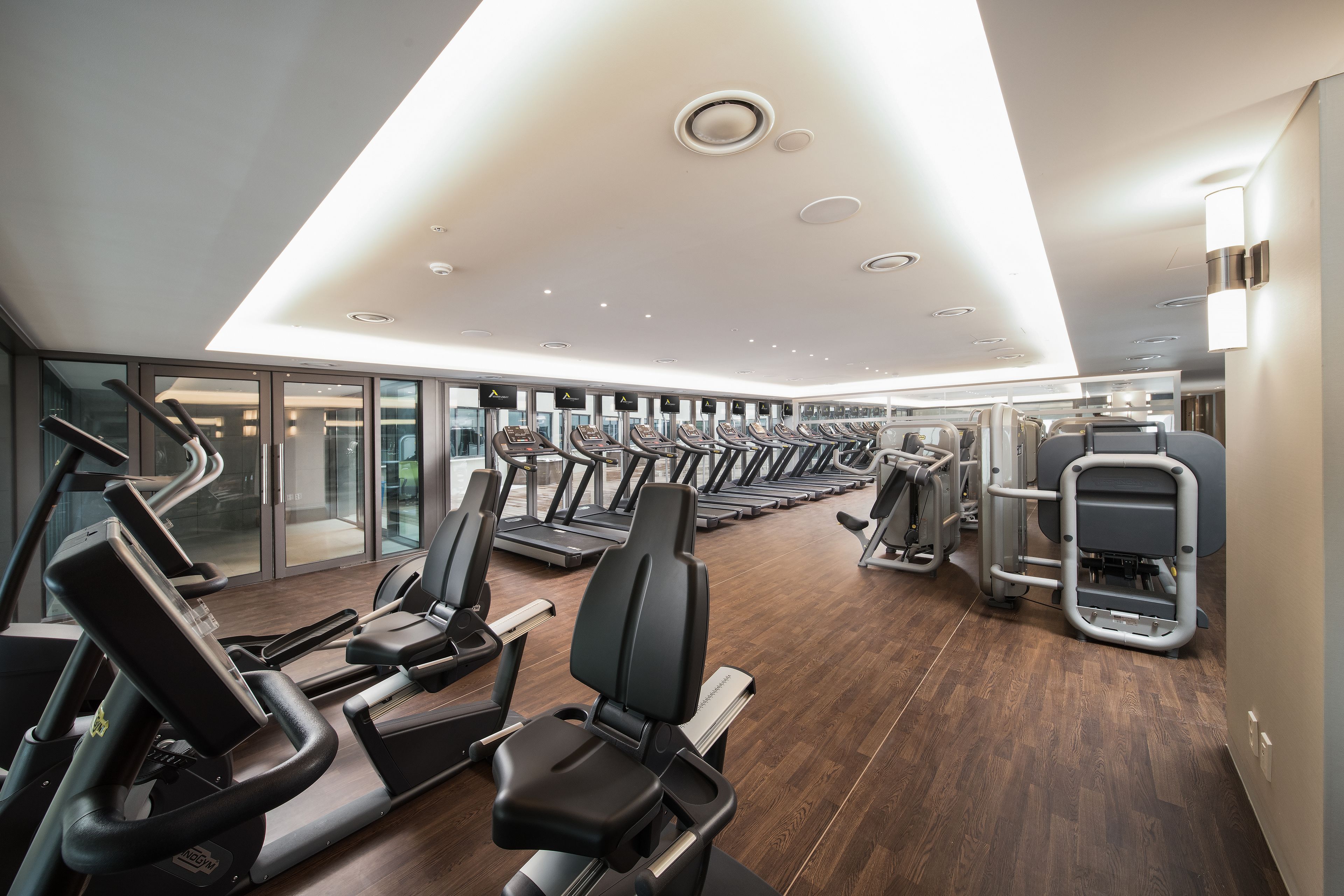Een moderne sportschool met diverse loopbanden, elliptische trainers en krachtstations.