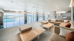 Un espace de détente moderne, doté de sièges et offrant une vue sur un plan d’eau.