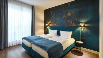 Un dormitorio con una cama grande, una mesita de noche y una lámpara fijada a la pared.