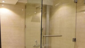 Une salle de bain moderne avec une douche à parois de verre, un plancher en bois et des toilettes blanches.