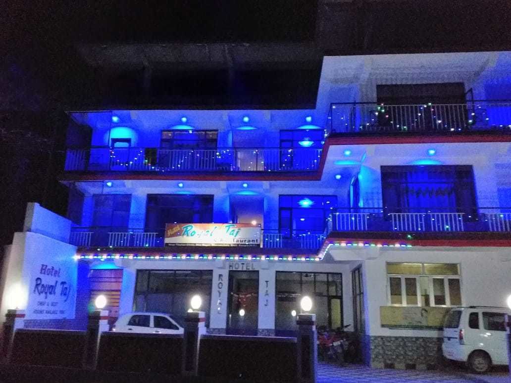 Un hotel con un cartel que dice "Royal Taj" y otro cartel para "Hotel Royal Taj".