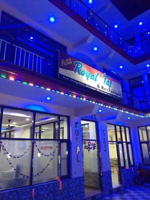Hotellet "Royal Taj" med skilt, der viser, at det ligger i nærheden af Tibetaner Klinik og Shiv Nagar.