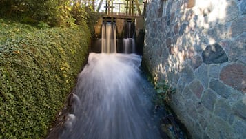 Eine steine Mauer mit einem kleinen Wasserfall.