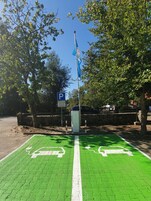 Un área de estacionamiento con carriles para bicicletas verdes y una bandera azul.