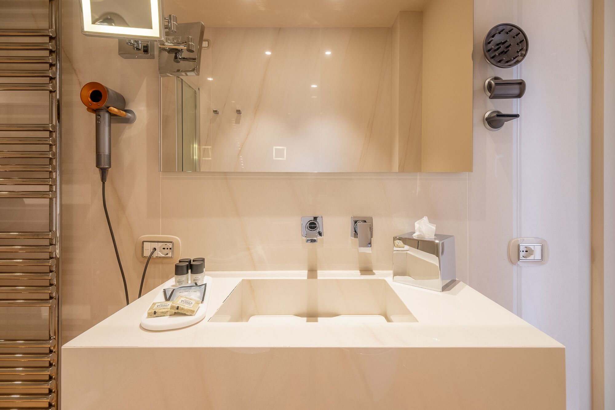 A modern bathroom with a large mirror, a sink, and a hairdryer.