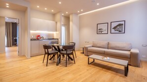 A modern living room with a sofa, coffee table, and dining area.