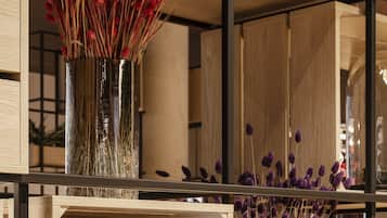 Une étagère avec une pancarte sur laquelle on peut lire « #ON SE SENT COMME À LA MAISON » et deux vases contenant des fleurs séchées.