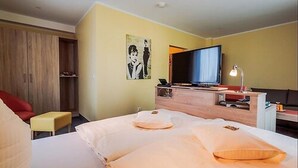 A hotel room with a bed, a TV, a desk, and a chair. - Hotel Restaurant Kasserolle (Siegburg)